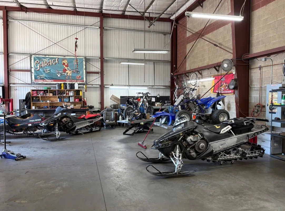 Inside the OHV Service Center & Fab shop in South Jordan with snowmobiles and bikes in for service